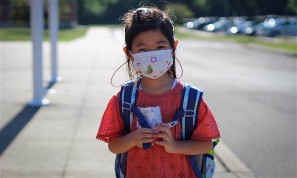 girl smiles while wearing mask